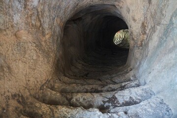 Obraz premium An underground passage carved into the rock leading up to the ancient tower