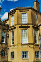 Classic European architecture with a clear blue sky. The building features a warm beige facade, large windows, and traditional stonework details in York, North Yorkshire, England.