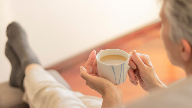 Mujer caf&eacute; manos relajante sof&aacute;