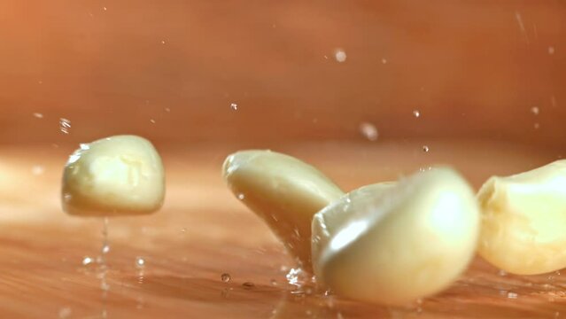 Super slow motion garlic falls on the table. High quality FullHD footage