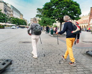 Two seniors enjoy urban exploration with walking sticks a tourist trip, showcasing active aging...
