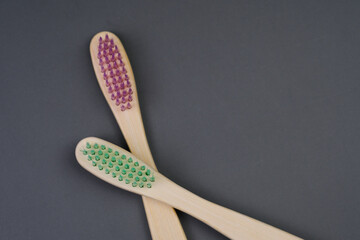 Two Wooden Toothbrushes With Green and Pink Bristles