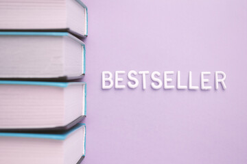 A stack of books with bestseller written on them in violet font on magenta and electric blue tints, creating a pattern of rectangles.