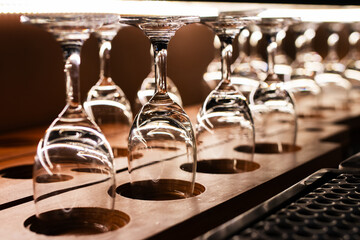 Row of the upturned crystal wine glasses on bar table