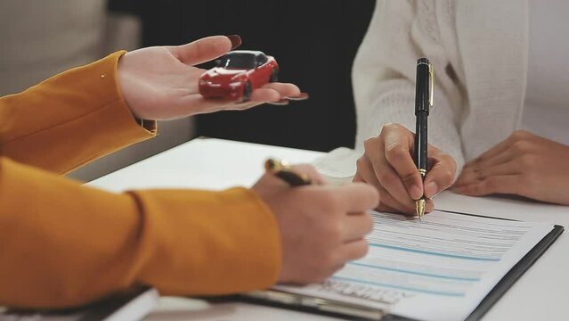 Insurance officers hand over the car keys after the tenant. have signed an auto insurance document or a lease or agreement document Buying or selling a new or used car with a car