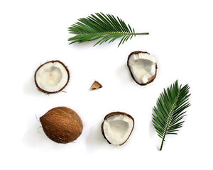 Coconut ( Cocos nucifera ) with halfs and palm leaves on a white background with space for text....