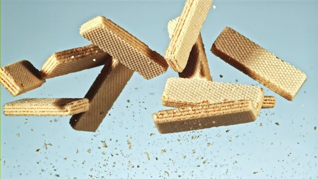 A creative and vibrant video showcasing falling wafers with crumbs on a blue background, featuring the word stockhouse. Ideal for snackrelated content, with elements of art and illustration