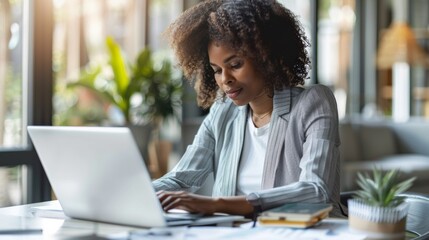 A woman sitting at a desk with her laptop open, AI - Powered by Adobe