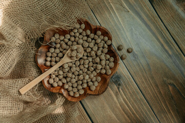 Breakfast cereal, bran with wooden spoon and ears of corn on wooden background