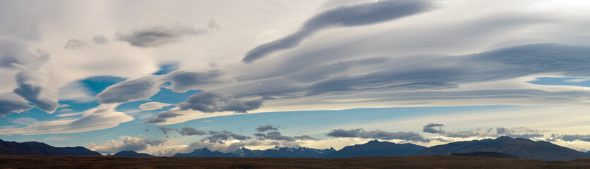 Dramatic Lenticular Clouds Hovering Over Mountain Range