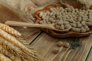 Breakfast cereal, bran with wooden spoon and ears of corn on wooden background