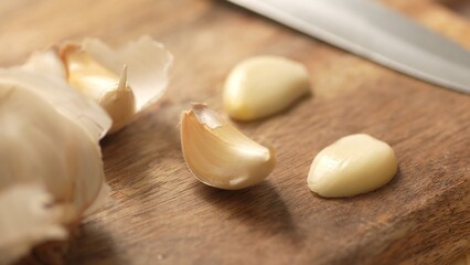 Obraz na płótnie Canvas Garlic cloves on a cutting board. Close-up, shallow dof.