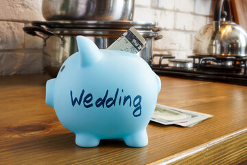 Savings piggy bank with the inscription wedding on the kitchen table.