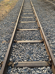 Train tracks are old rusty steel on a railroad for travel in Asia