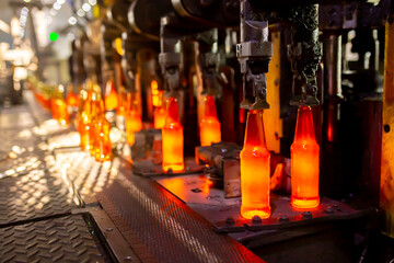 Glass factory, production of glass containers. Molten glass is blown into molds. Robotics in...