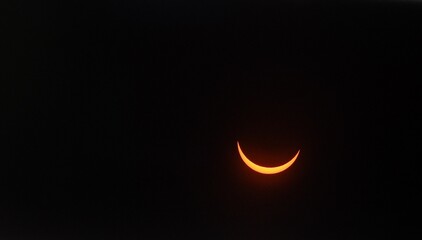 Solar eclipse with a glowing crescent in the dark sky