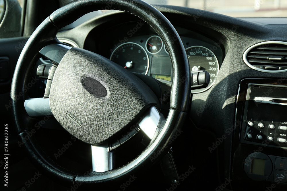 Wall mural Black steering wheel and dashboard in car