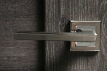 Wooden door with metal handle, closeup view