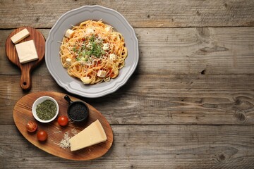 Vegetarian meal. Tasty pasta and fresh products on wooden table, flat lay. Space for text