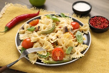 Vegetarian pasta with mushrooms, basil, string beans and tomatoes on table, closeup