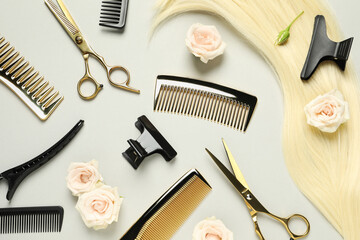 Flat lay composition with professional hairdresser tools, flowers and blonde hair strand on light grey background - obrazy, fototapety, plakaty