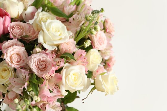 Beautiful bouquet of fresh flowers near white, closeup. Space for text