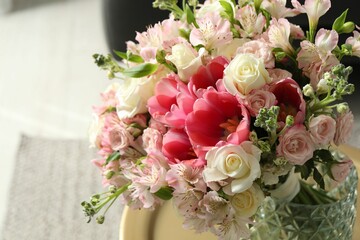 Beautiful bouquet of fresh flowers on table in room, closeup