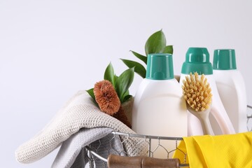 Set of different cleaning supplies in basket on white background