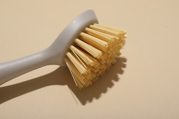 Cleaning brush on beige background, closeup. Space for text