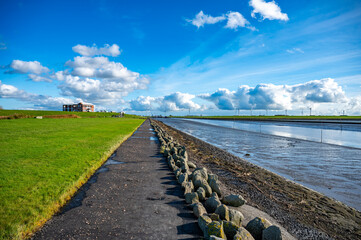 Waterfront of Husum with meadow on the left and sea on the right, beautiful clouds and wind...