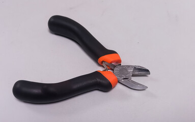 Obraz premium Pliers in red and black colored handle on a white background. Blank text space. Steel cutting pliers.