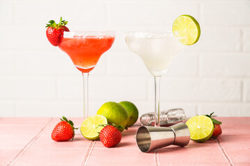Classic and strawberry margarita in tall glasses with tequila, ice and lime at color background. - 780620883