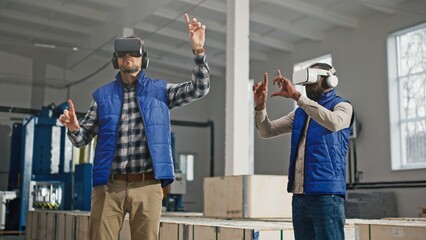 Multi-ethnic co-workers using Virtual Reality headsets for possible improvements in production....