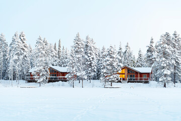 Winter view of a mountain lodge surrounded by frozen forest covered with snow in Swedish Lapland, Sweden, Scandinavia