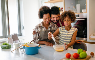 Happy african american parents and child having fun preparing healthy food in kitchen - obrazy, fototapety, plakaty