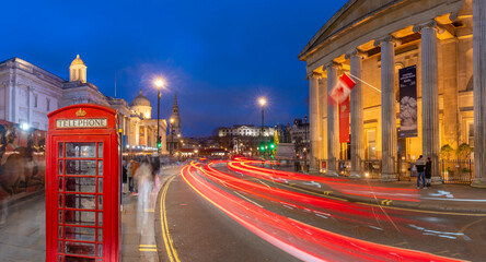 View of red telephone box and Trafalgar Square at dusk, Westminster, London, England, United Kingdom