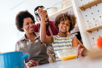 Happy african american family preparing healthy food in kitchen, having fun together on weekend - 780627479