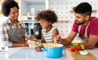 Happy african american family preparing healthy food in kitchen, having fun together on weekend - 780628231