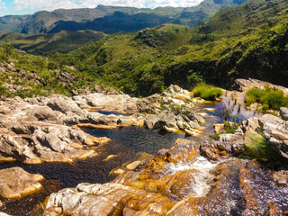 Naklejka premium Beautiful waterfall that has a mirror effect as it reflects the water on the stone walls on the banks. It is located in Serra do Cipó in Brazil