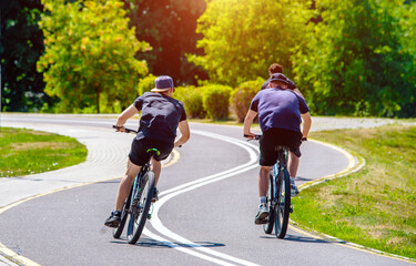 Fototapeta premium Cyclists ride on the bike path in the city Park 