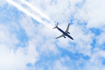 Passenger airplane flying far away in the clouds sky
