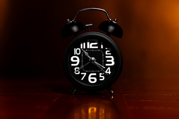 Black retro alarm clock on wooden table