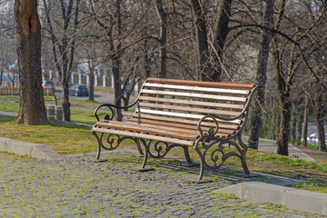 Wooden Bench With Cast Iron at Town Park Sunny Spring Day in Craiova Romania