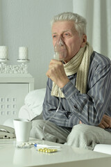An elderly man is sick and uses an inhaler