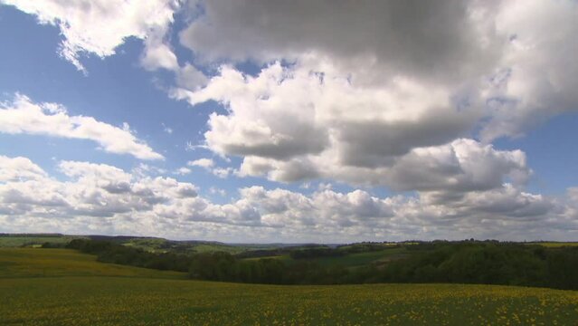 Clouds drift across the sky over meadows in spring