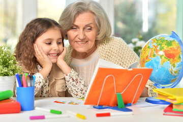 Happy Grandmother with granddaughter drawing together