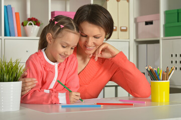 Mom and daughter draw at home together.