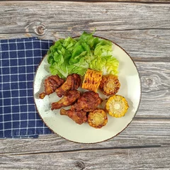 Foto op Plexiglas pilons de poulet et maïs grillé dans une assiette  © ALF photo