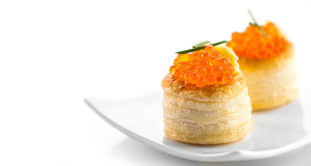 Tartlet with red caviar close up. Gourmet food closeup, appetizer. Close-up salmon caviar. Delicatessen. Tartlets isolated white background. Texture of caviar. Seafood.