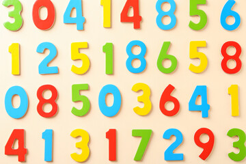 Colorful numbers on beige background, flat lay